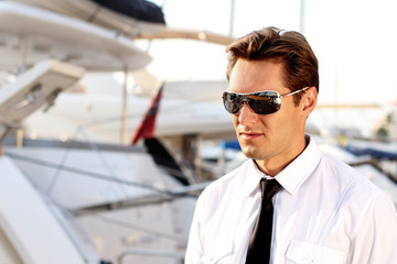 Portrait of Casual man wearing sunglasses,  over yacht outdoors