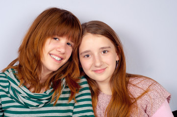 Obraz premium Portrait of two pretty teenage girlfriends smiling