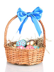 Colorful Easter eggs in the basket with a blue bow isolated