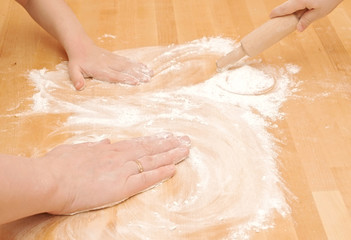 Fototapeta premium A child is helping mom to knead the dough for baking