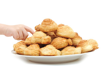 Children's hand goes to the plate in the baking