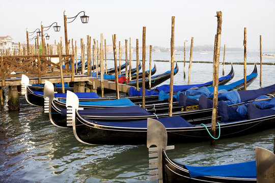 Gondolas tied to wooden poles in Venice, Italy