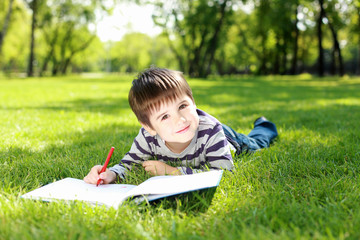 Portrait of a boy with a book in the park