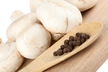 Fresh mushrooms with spoon of pepper