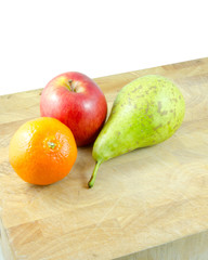 orange, pear and apple on chopping board