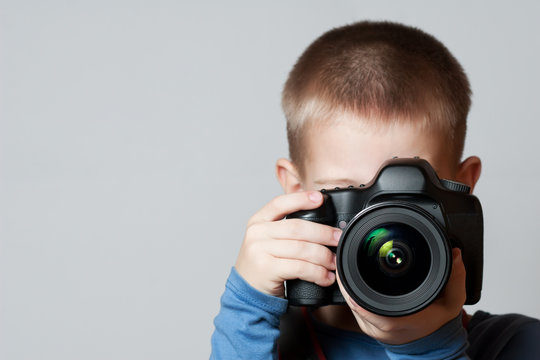 Little Boy holding camera and taking photo
