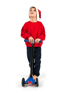 Kid With Christmas Hat And Scooter On White Background.