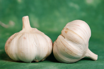 two closeup garlics on green background