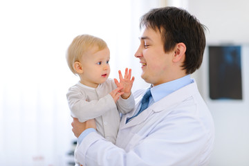 Portrait of pediatrician with baby on hands