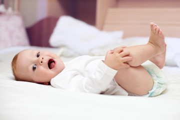 portrait of a cute baby lying on bed at home