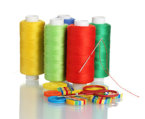 Many bobbin of thread with needle and buttons isolated on white