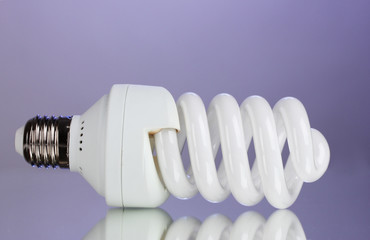 energy saving light bulb on purple background.