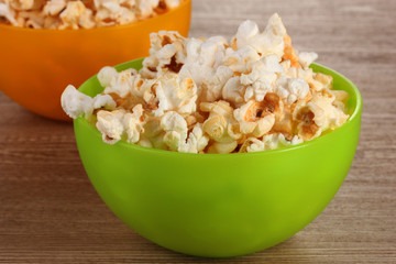 popcorn in bright plastic bowls on wooden table