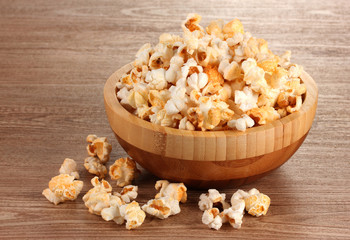 popcorn in wooden bowl on wooden table