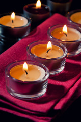 Close-up of tea light candles burning in the darkness