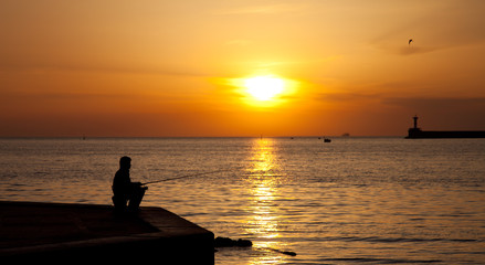 Obraz na płótnie Canvas Silhouettes of Fishermen at sunset