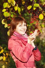 Woman with wild apple in the autumn