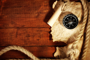old paper, compass and rope on a wooden table