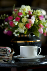 Coffee cup with flower and newspaper