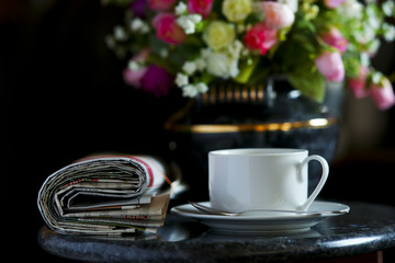Coffee cup with flower and newspaper