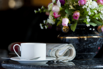 Coffee cup with flower and newspaper