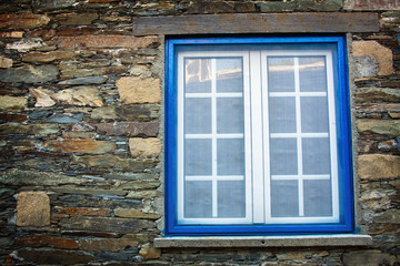 Ancient blue window on a wall made of schist