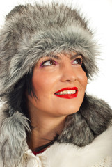 Elegant woman in fur hat looking up