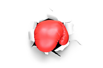 A boxing glove through a hole in paper