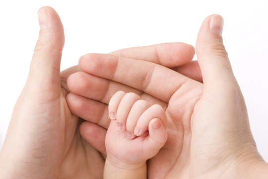 Close-up of baby's hand holding mother's finger
