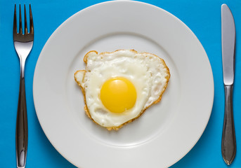 Fried egg on a plate with flatware