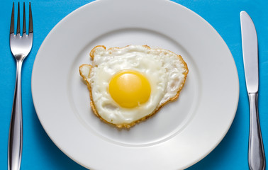 Fried egg on a plate with flatware