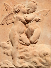 Fototapeta na wymiar dwa całując ulgę anioły w Toskanii terakota, Włochy