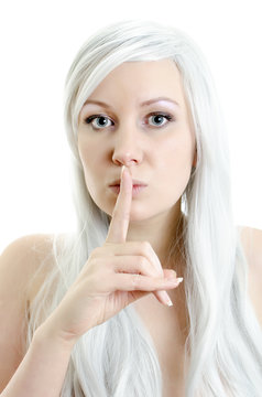 blond girl with a finget at lips isolated on white