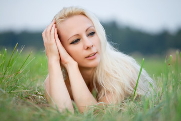 Naklejka premium young woman laying in the grass