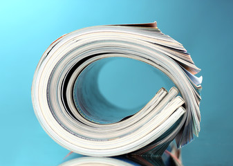 Rolled up magazines on blue background