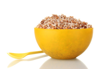 Boiled buckwheat in a yellow bowl isolated on white