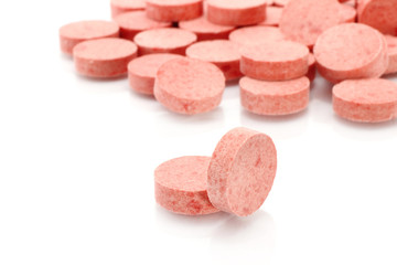 Obraz na płótnie Canvas Red medicine pills close-up on a white background