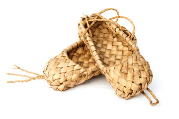 Old Russian sandals made of bark on a white background