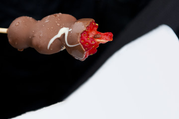 strawberries on wooden stick covered with chocolate