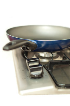 Frying pan on a stove against white.