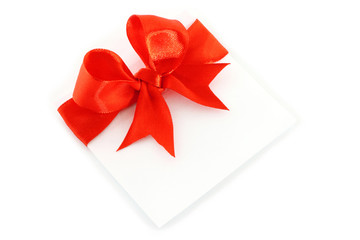 Sheet with red holiday bow on white background