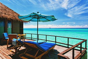 Overwater villa balcony overlooking tropical lagoon