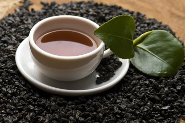 A cup of green tea with freh leaves