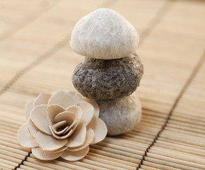 Fototapeta na wymiar pierres en équilibre et fleure en bois