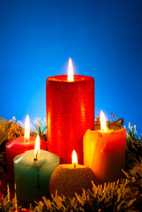 Five burning colourful candles against blue background
