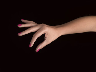Fototapeta premium Close-up of beautiful woman's hand, taking something. Black back