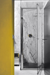 cabina doccia con porta in vetro e rivestimento di marmo