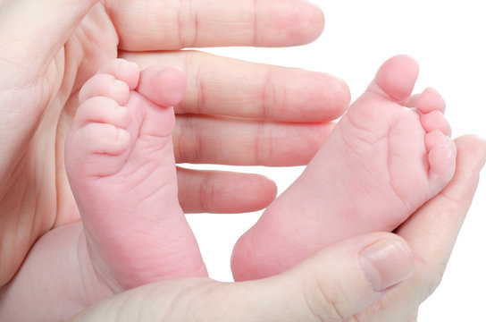 Mother's hands holding baby's feet