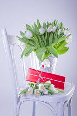 White chair with tulips and red gift, silver angel ribbon