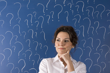 thinking business woman in front of question marks